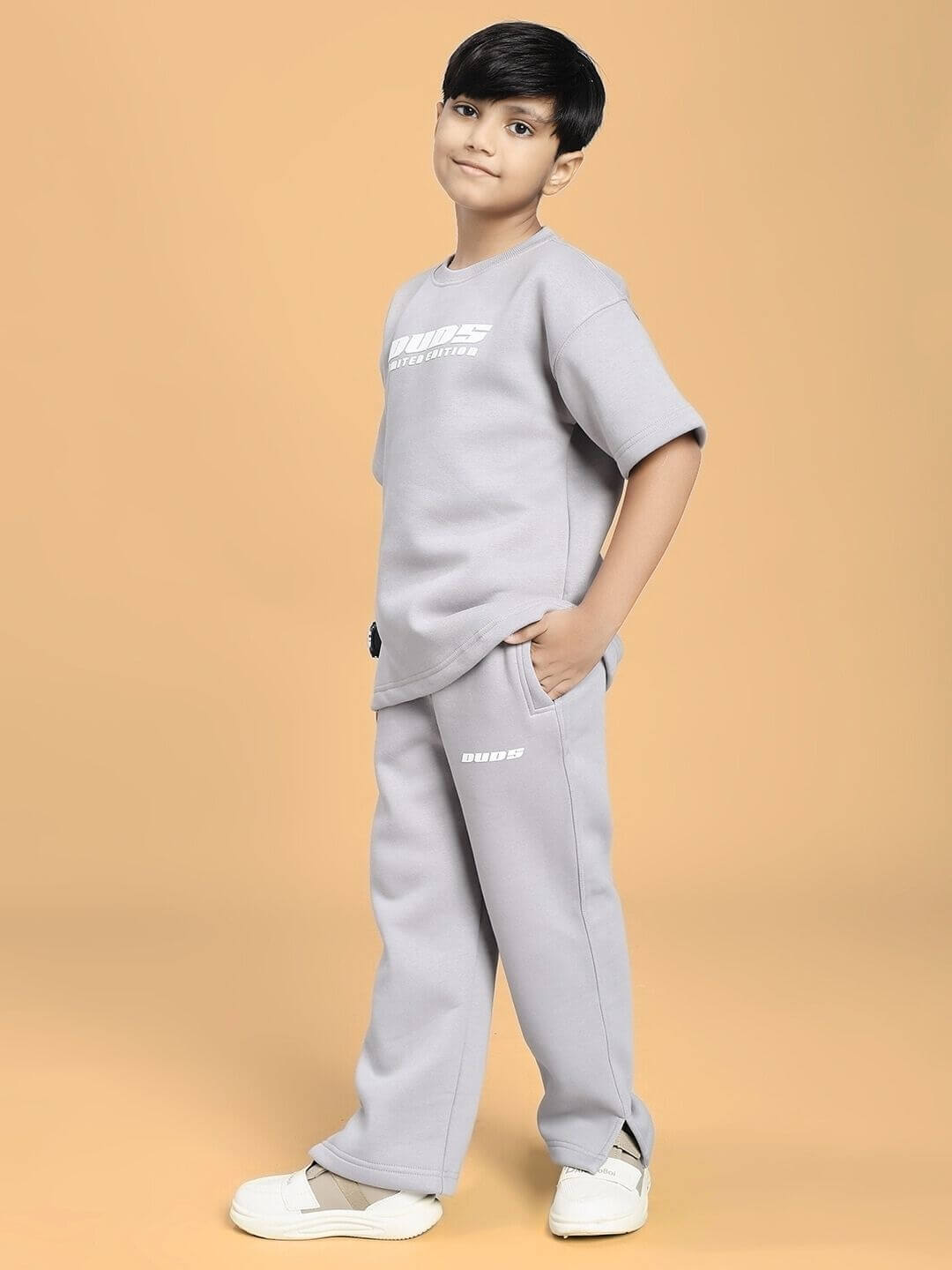Child wearing SKODA FLEECE CO-ORD FOR BOYS AND GIRLS GREY on a warm-colored background, showcasing comfortable fall fashion.