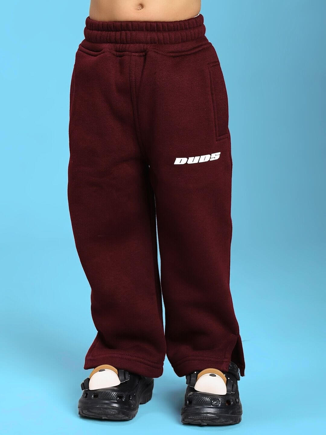 Child wearing SKODA FLEECE JOGGER FOR BOYS AND GIRLS MAROON with logo, front view, studio background.