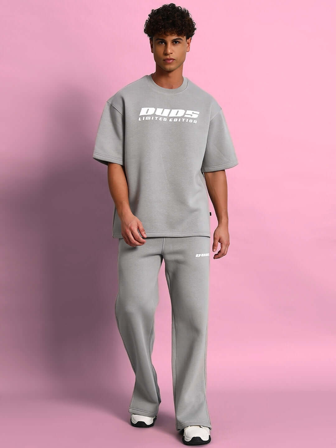 Person wearing SKODA COTTON FLEECE CO-ORD GREY set against a pink background.