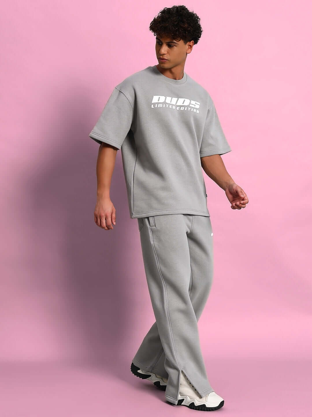 Person wearing SKODA COTTON FLEECE CO-ORD GREY set against a pink background.