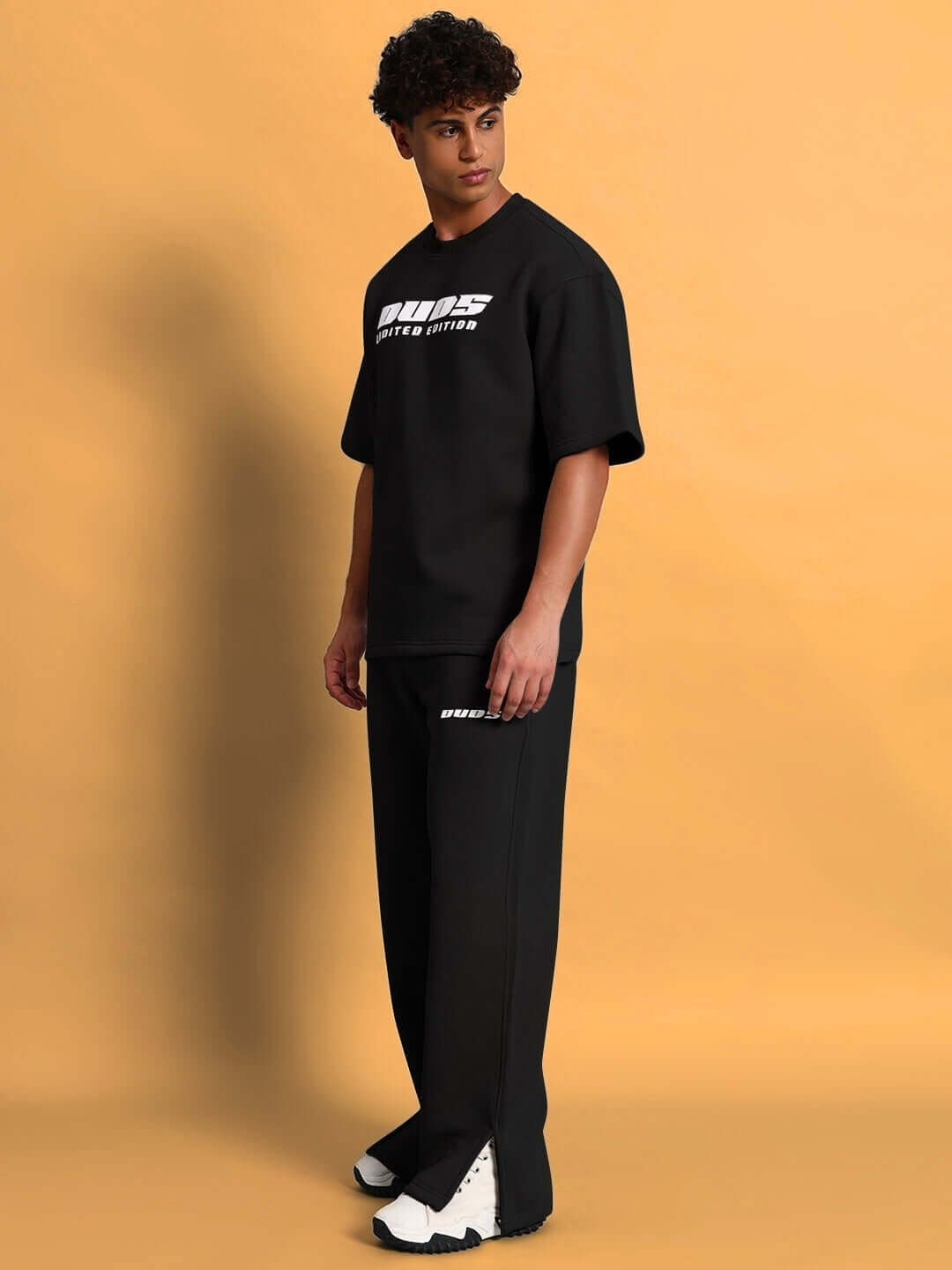 Man wearing WEARDUDS SKODA FLEECE CO-ORD BLACK on beige background.