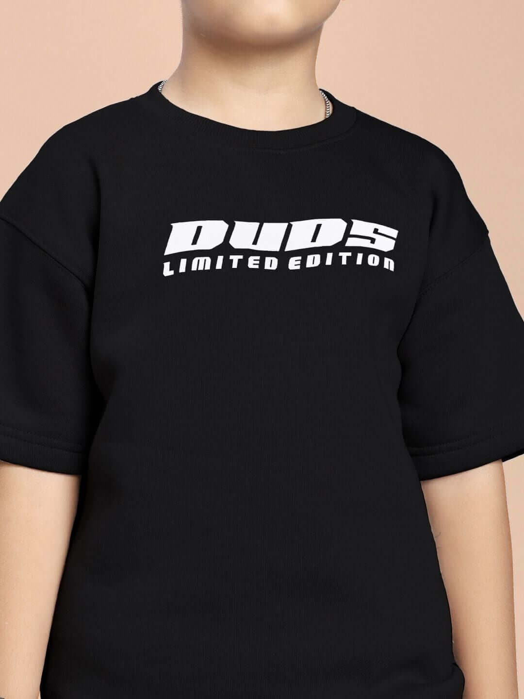 Child wearing a black SKODA FLEECE CO-ORD FOR BOYS AND GIRLS BLACK with 'DUDS Limited Edition' text on the shirt.