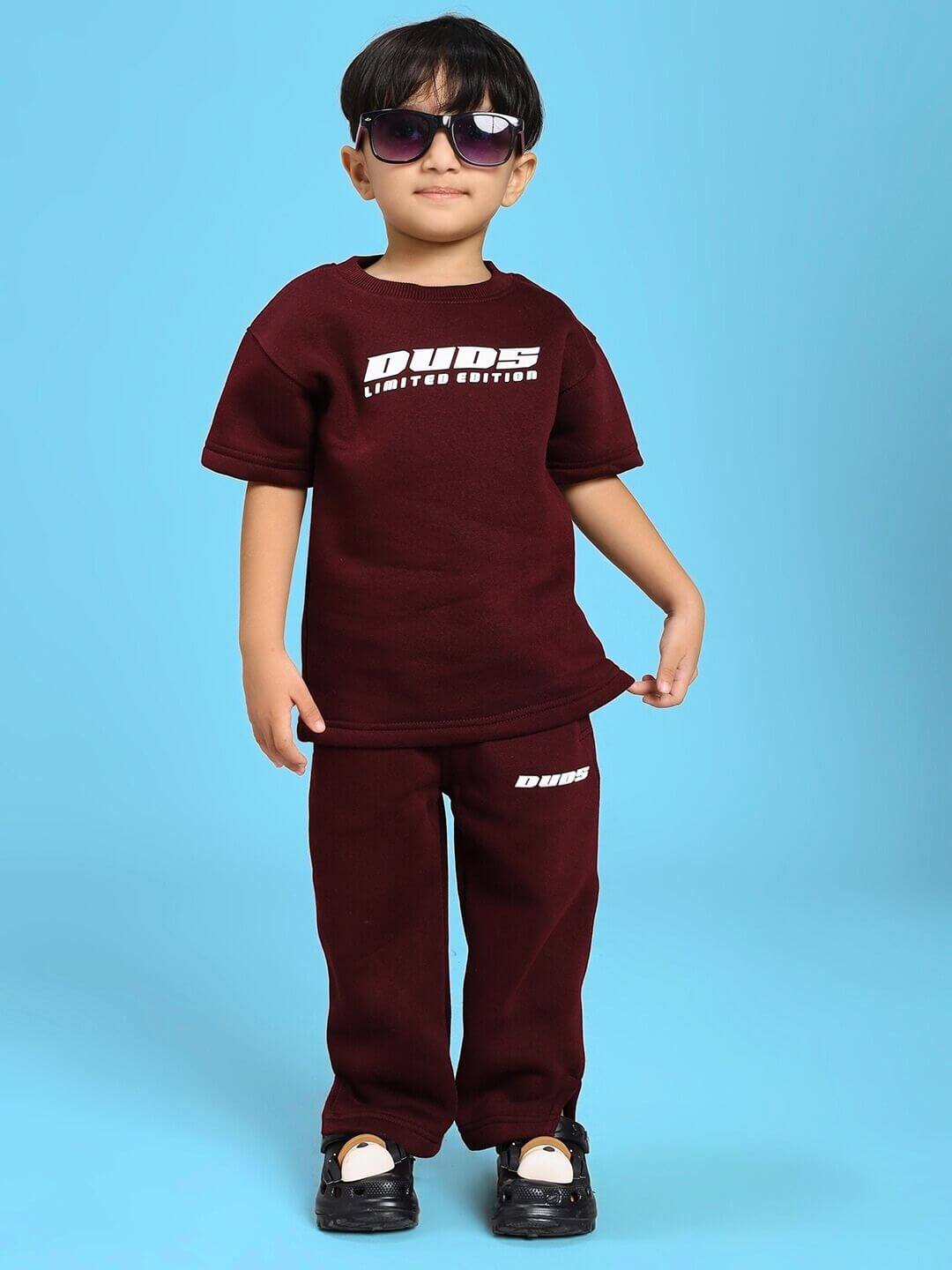 Child wearing SKODA FLEECE CO-ORD FOR BOYS AND GIRLS MAROON with sunglasses, featuring a trendy hoodie and joggers set.
