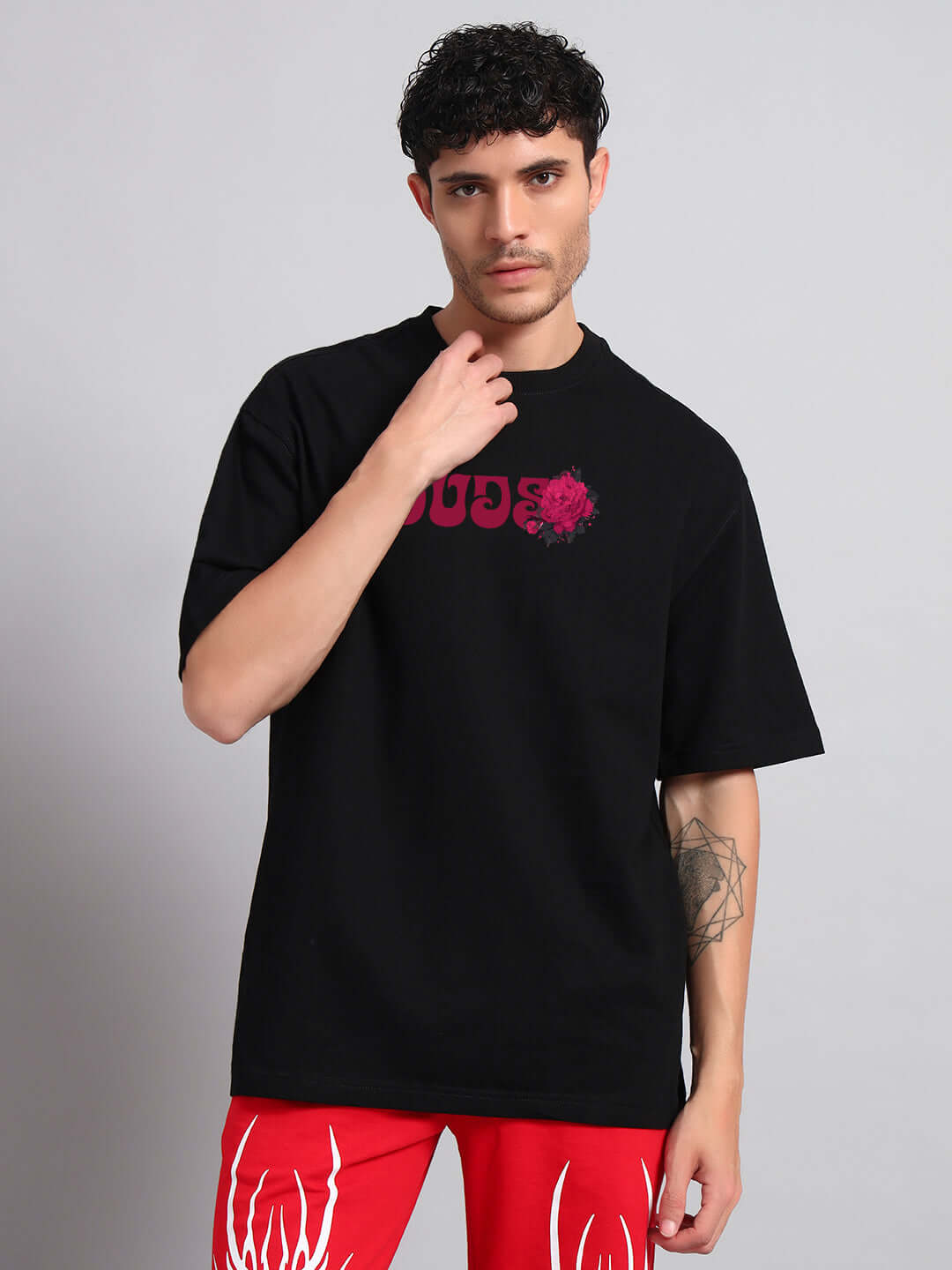 Man wearing black Skull Roses oversized t-shirt, perfect for trendy summer looks with relaxed fit and lightweight cotton material.