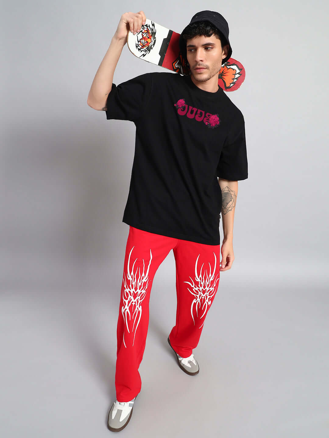 Model wearing Skull Roses Oversized T-Shirt Black with skateboard, showcasing relaxed fit and edgy street style.