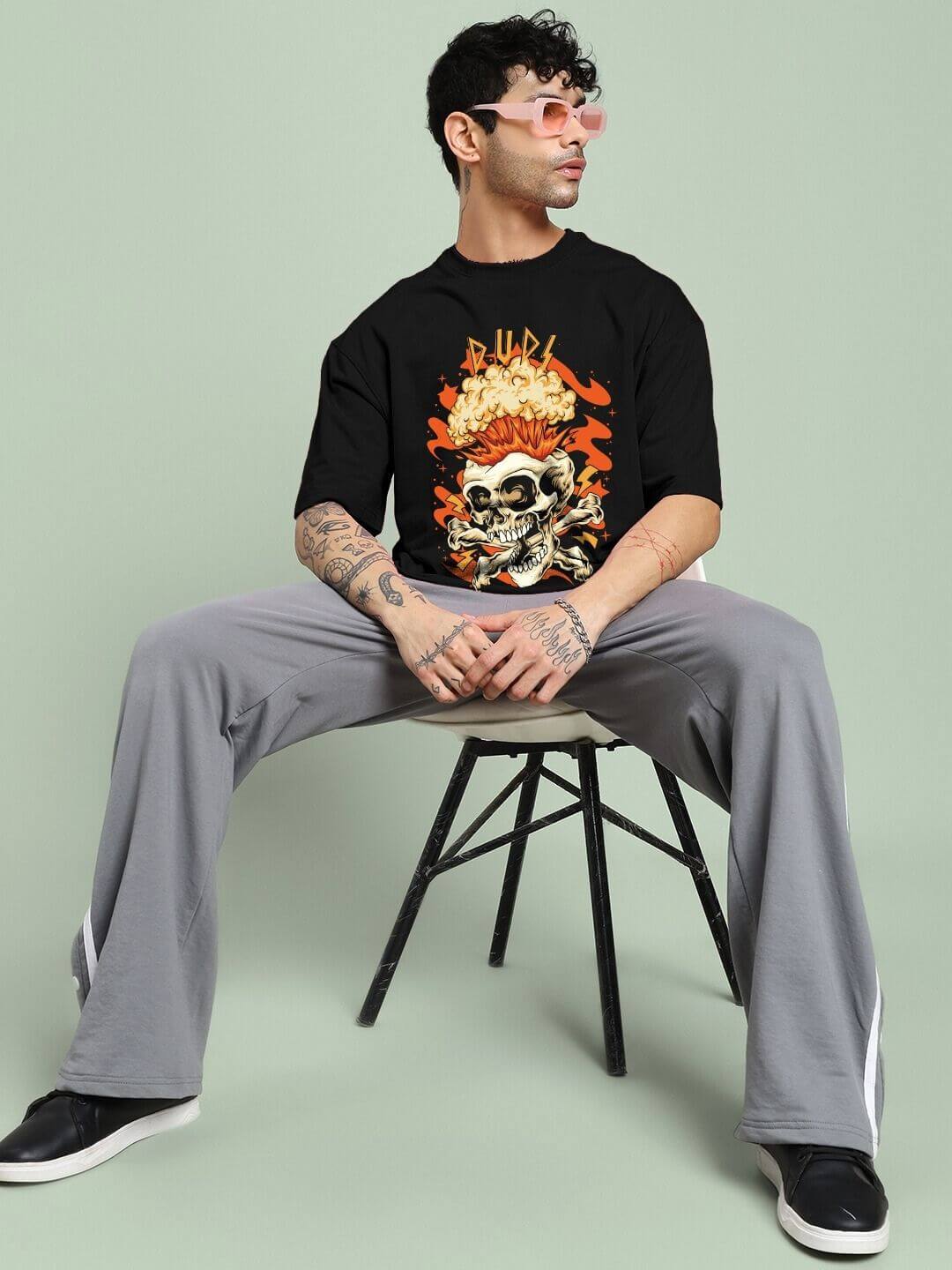 Person wearing SKULL BLAST FIRE PRINT OVERSIZED T-SHIRT BLACK with skull and fire design