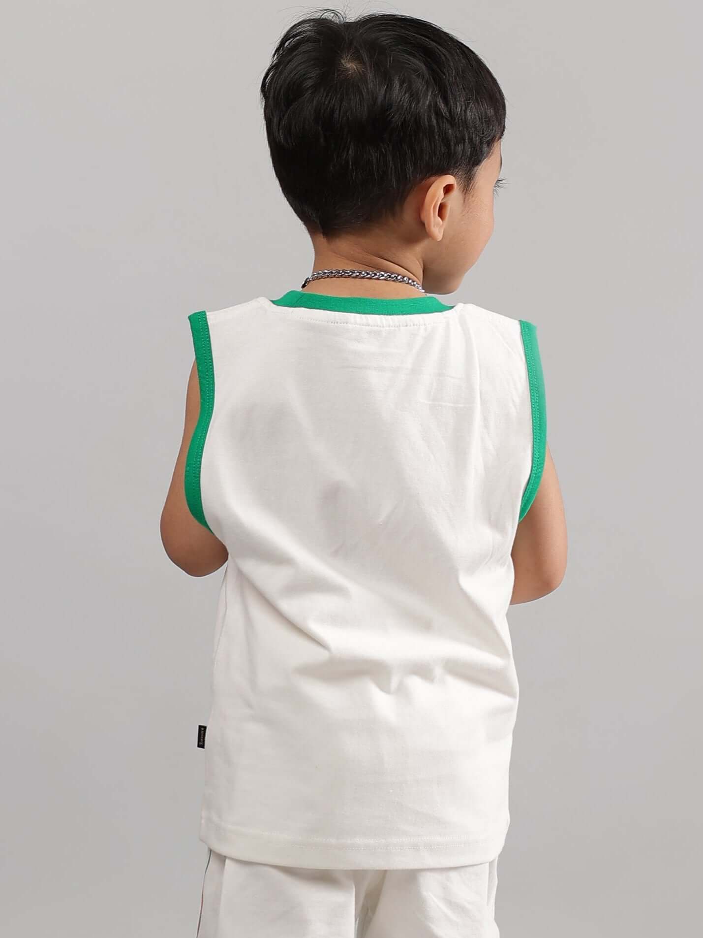 Child wearing off-white sleeveless shirt with green trim, suitable for boys and girls. Made to order by DUDS.