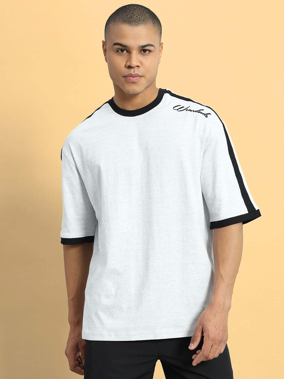Model wearing a grey melange SMASH oversized t-shirt made from premium cotton French terry with black accents, suitable for casual wear.