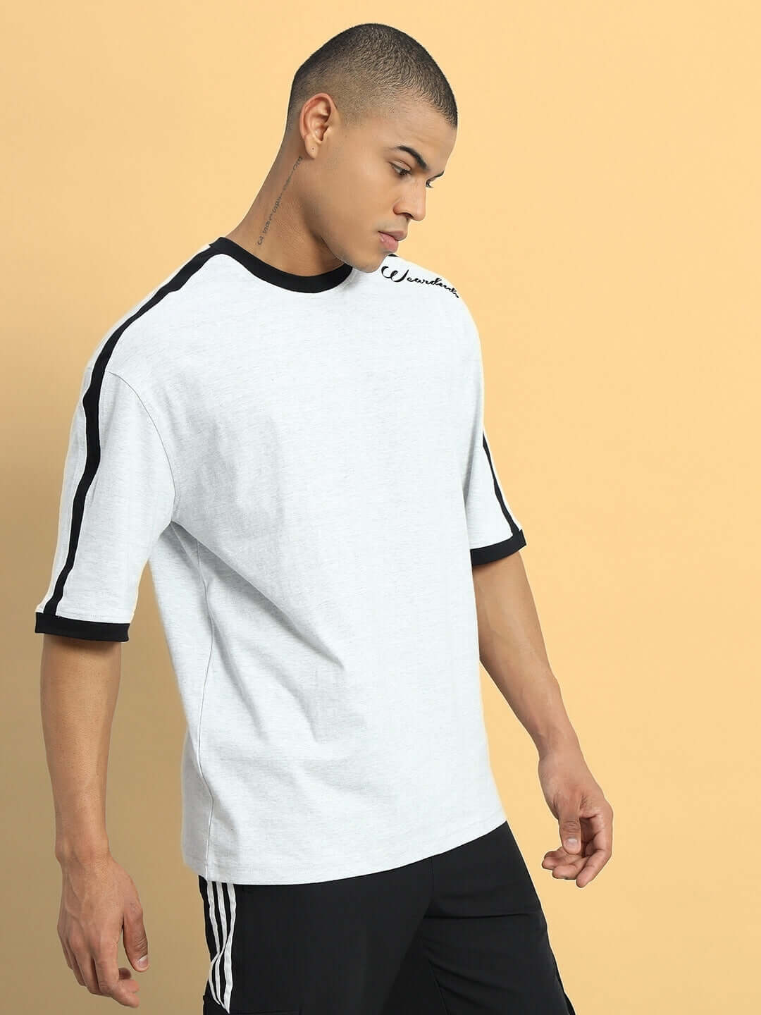 Model wearing grey melange SMASH oversized t-shirt made from premium cotton blend, showcasing relaxed fit and stylish design.