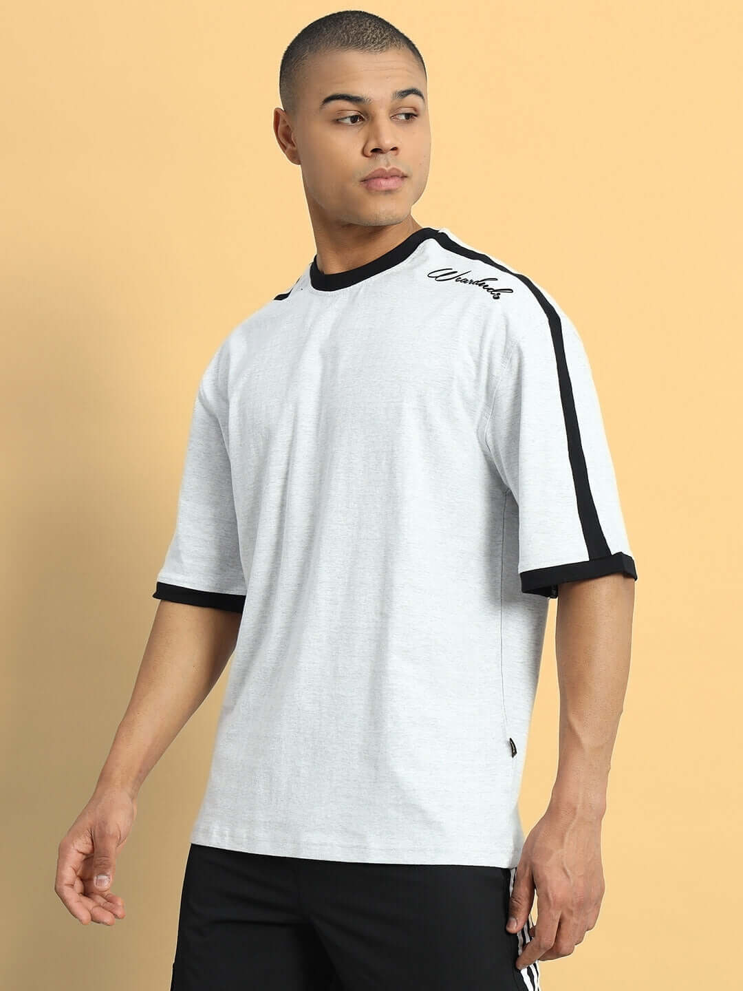 Model wearing grey melange oversized t-shirt with black stripes, made from premium heavy gauge fabric, blend of cotton and elastane.