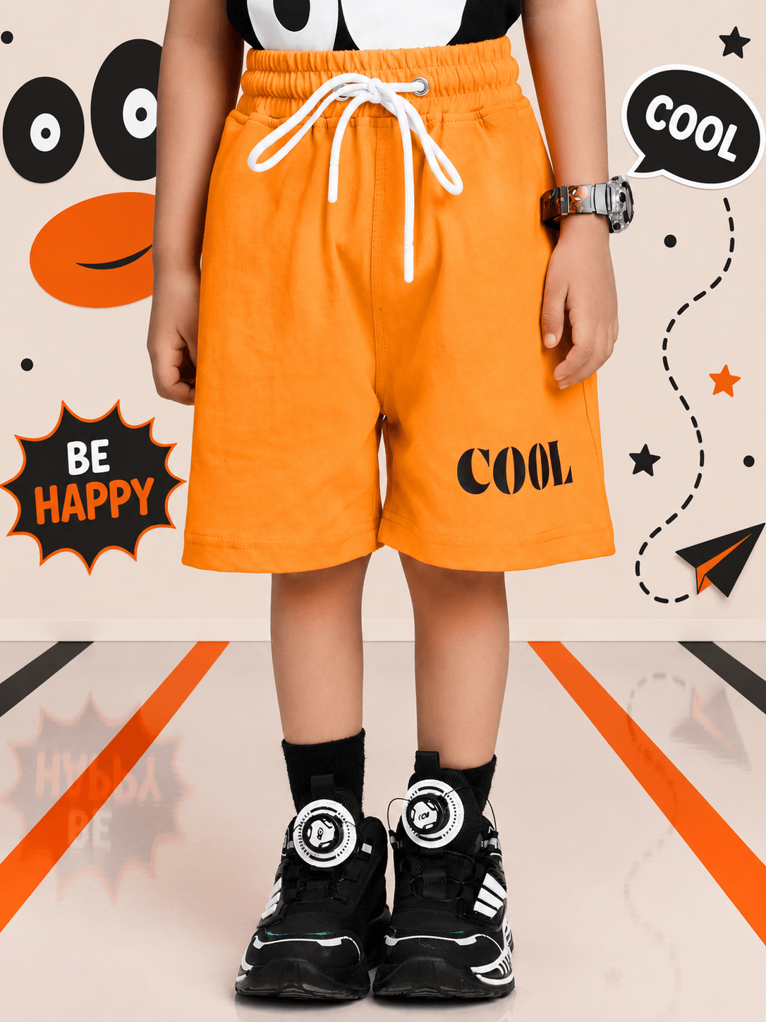 SMILEY EYES PRINT CO-ORD SET FOR BOYS GIRLS BLACK ORANGE featuring vibrant orange shorts and stylish sneakers.
