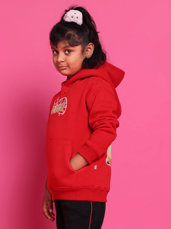 Child wearing SNAIL OVERSIZED HOODIE BOYS & GIRLS RED against pink background, showcasing the custom fit design by DUDS tailors.