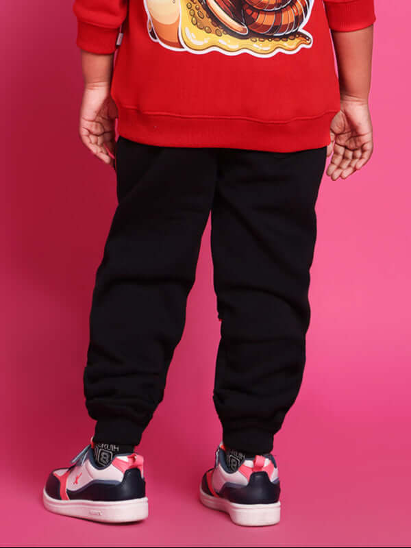 Child wearing Snail relaxed fit jogger, black, paired with a red sweatshirt featuring a snail design, perfect for boys and girls.