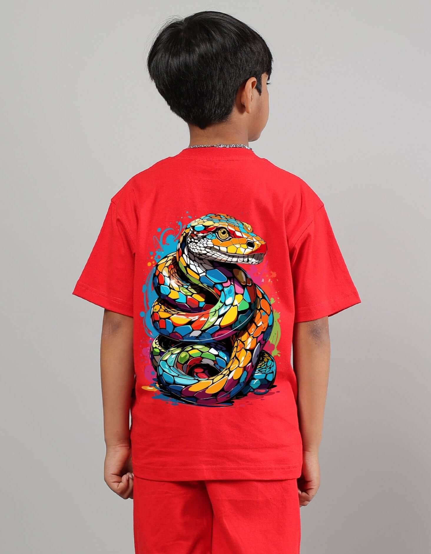 Child wearing a red snake skin t-shirt for boys and girls, featuring a colorful snake pattern on the back, made to order by DUDS.