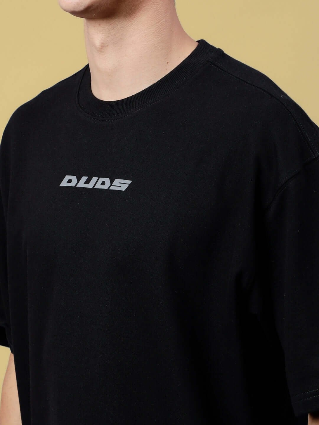 Black oversized T-shirt with "SONIC SOUND REFLECTOR" logo, made of premium cotton fabric, shown from the chest in profile view.