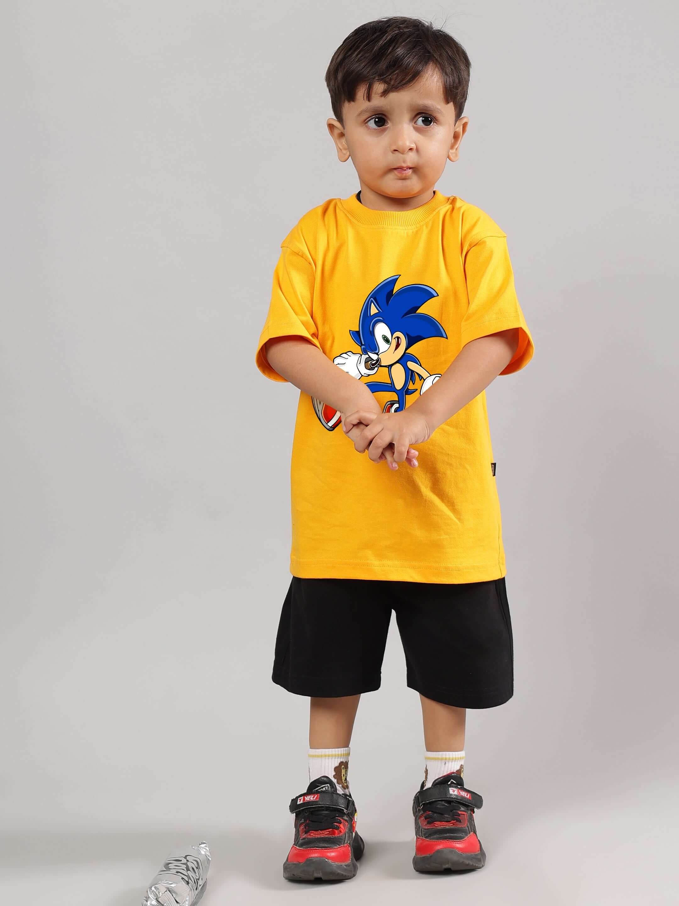 Young child wearing SONIC SUMMER CO-ORD FOR BOYS GIRLS YELLOW-BLACK with Sonic print, perfect for playful fashion.