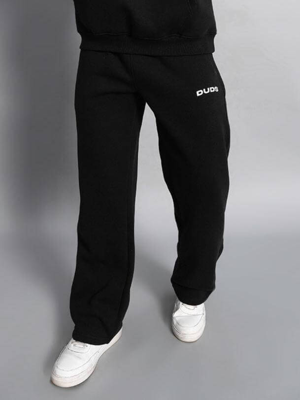 Model wearing WEARDUDS SOOTY FLEECE PANT BLACK, tailored fit, standing against a neutral backdrop, showcasing comfort and style.