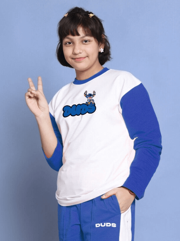 Child wearing SORE oversized sweatshirt in white-blue, made of 100% cotton, smiling and posing with a peace sign.
