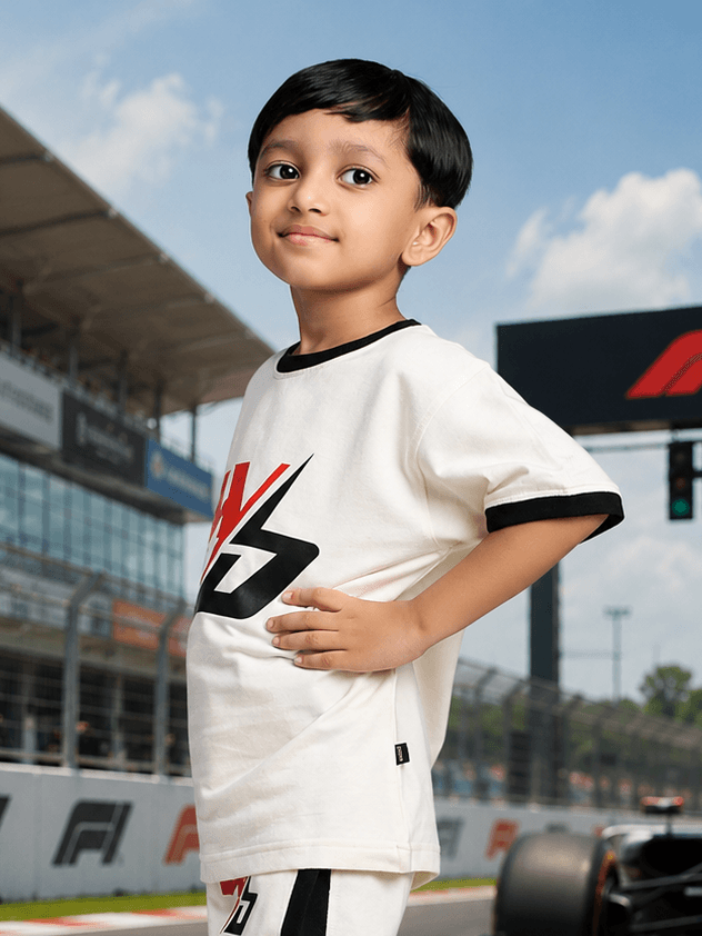 SPEED SURGE T-SHIRT FOR BOYS GIRLS WHITE worn by a smiling child at a racetrack.