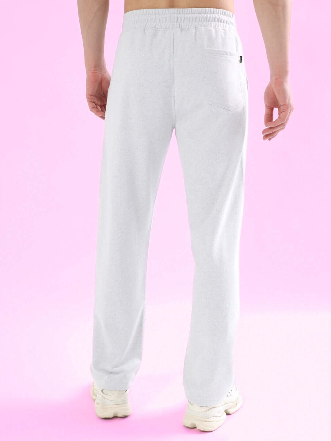 Back view of light grey joggers with spider web design from DUDS tailored collection on pink background