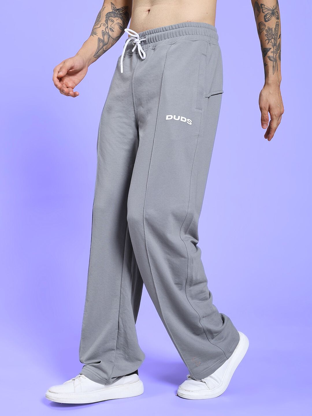 Model wearing SPIRAL RELAXED-FIT JOGGERS GREY, showcasing casual and comfortable fit, side view with white sneakers, styled for everyday wear.