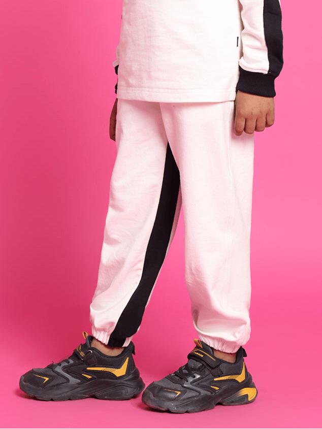 Child wearing SPLINTER OVERSIZED CO-ORD SET FOR BOYS GIRLS OFF WHITE BLACK on a pink background, showcasing stylish casual wear.