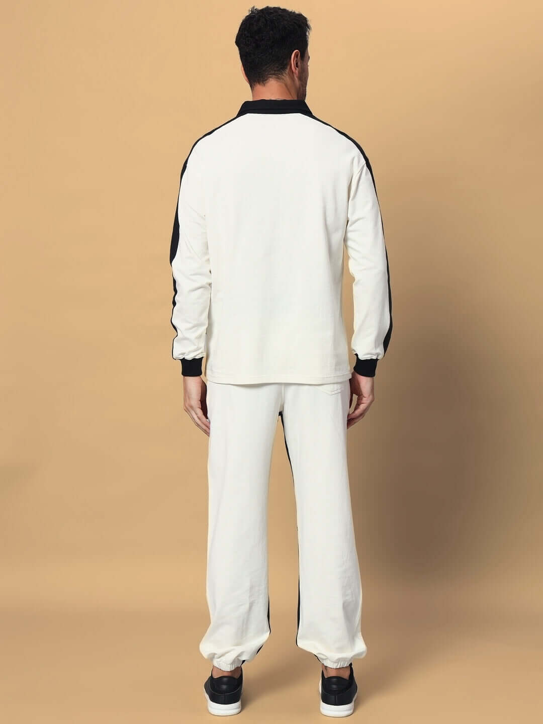 Back view of a model wearing the SPLINTER oversized co-ord set in off white-black, featuring relaxed fit joggers with elastic waistband.