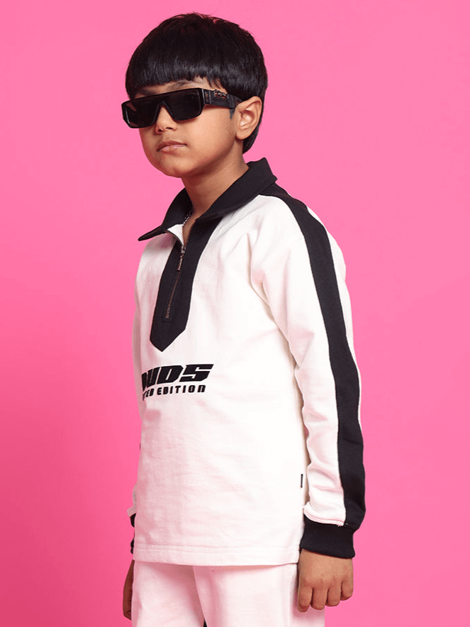 Child wearing Splinter over-sized sweatshirt in off white-black, made of 100% cotton, standing against a pink background
