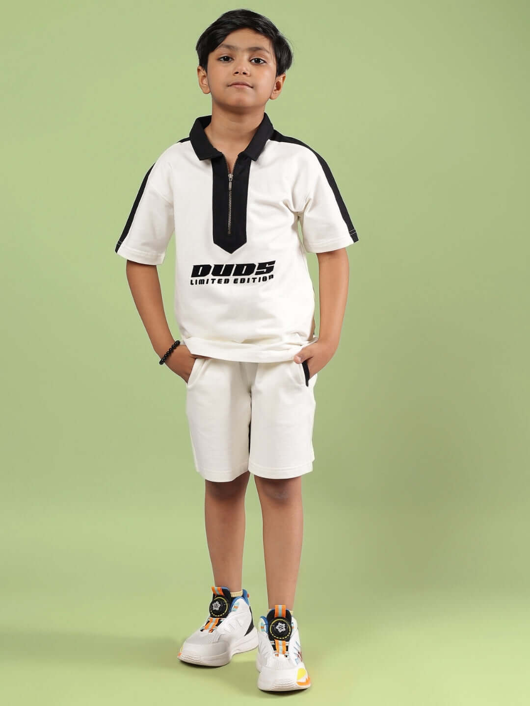 Child wearing off-white SPLINTER summer co-ord outfit by DUDS with black accents, perfect for boys and girls. Custom sizes available.