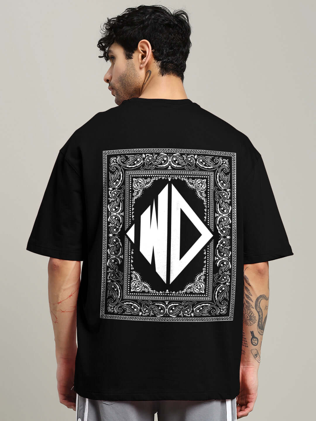 Man wearing a black square frame oversized t-shirt made from premium cotton fabric, featuring white graphic design on the back.