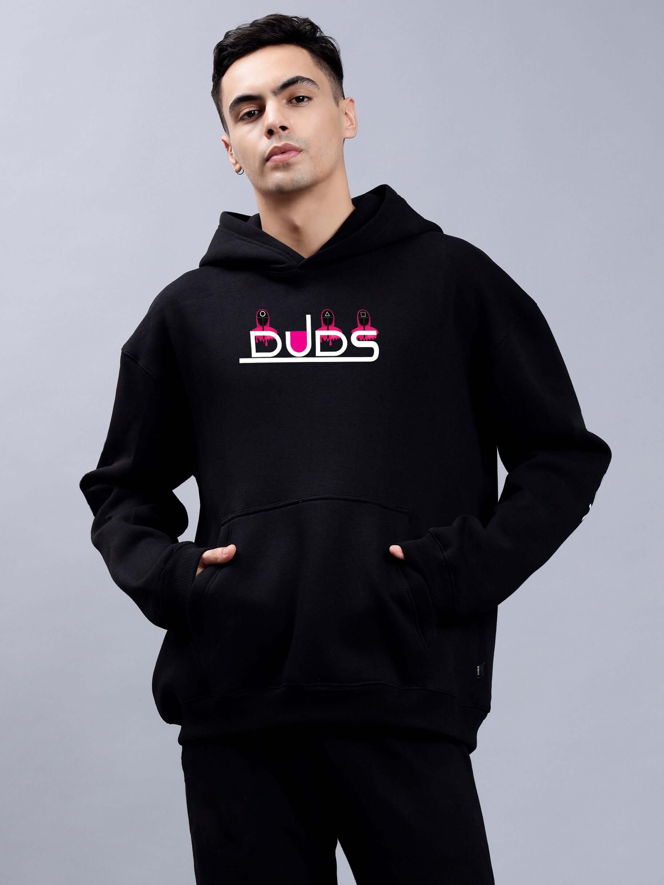 Man wearing SQUID GAME OVERSIZED HOODIE MEN BLACK, inspired by the cult-favorite series, with streetwear style.