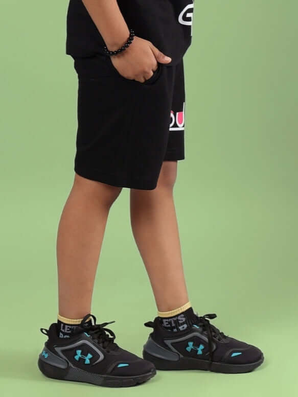 Child wearing black Squid Game shorts, styled with casual shoes and a bracelet, showcasing DUDS custom fit design for boys and girls.