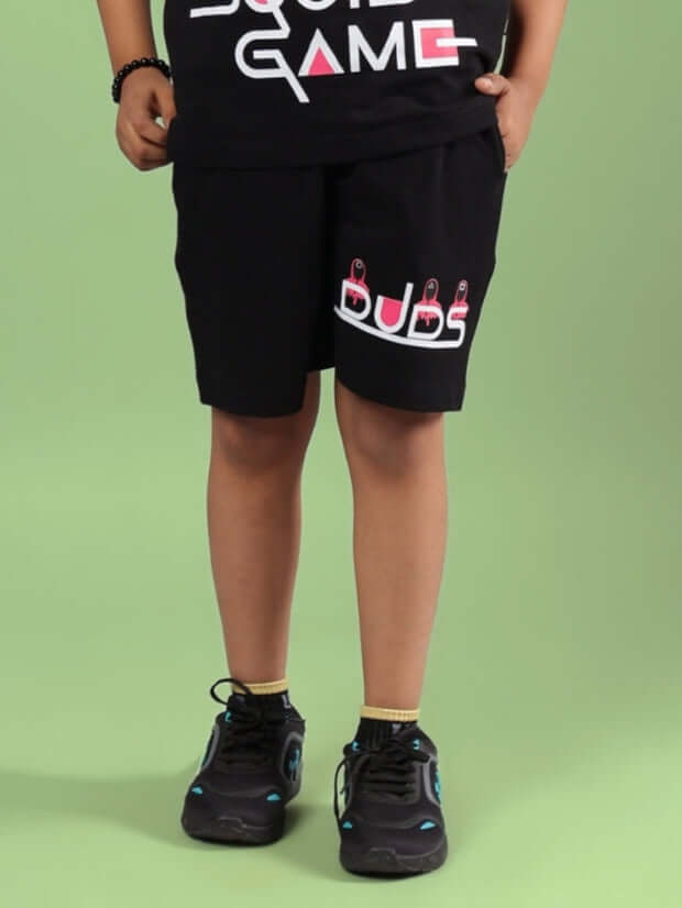 Child wearing black Squid Game shorts with DUDS logo, perfect for boys & girls, customizable sizing available.