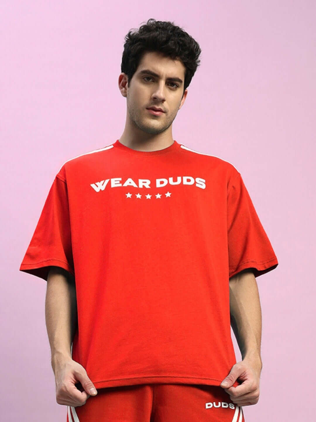 Model wearing STAR JUMPER oversized red t-shirt made of premium cotton fabric, featuring stylish design. Perfect for casual wear.