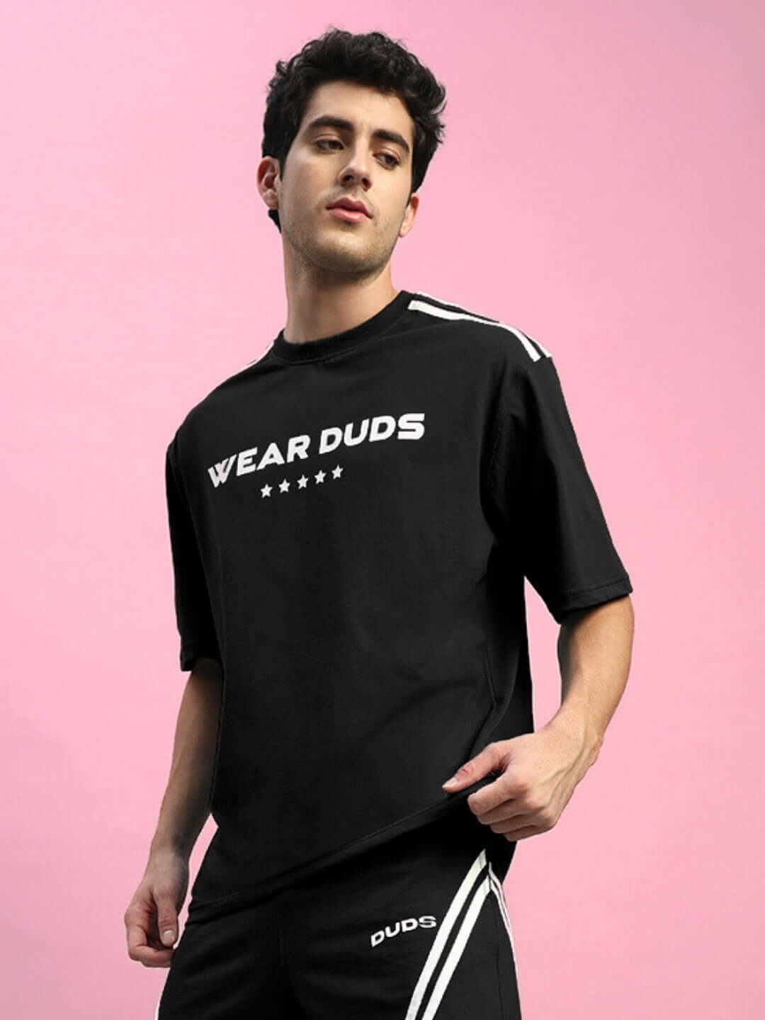 Model wearing STAR JUMPER OVER-SIZED T-SHIRT BLACK with bold energy streetwear style, crafted from breathable cotton for comfort and style.