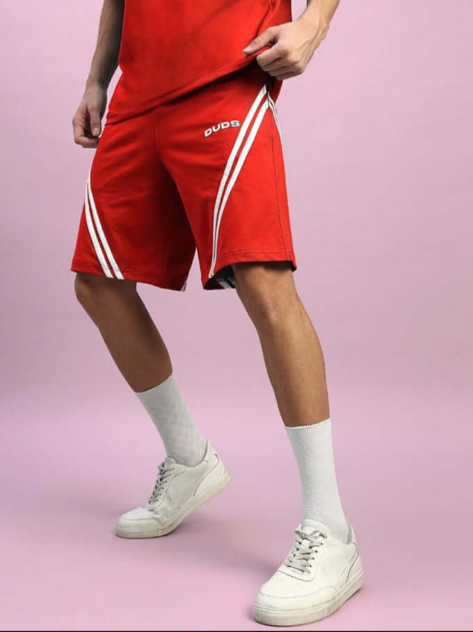Man wearing red STAR JUMPER REGULAR FIT SHORTS by DUDS with white stripe design.