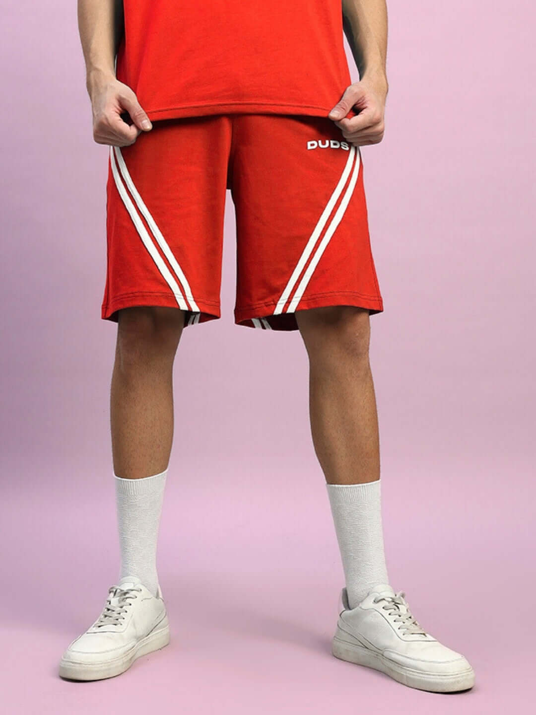 Red STAR JUMPER regular fit shorts with white stripes, modeled with casual sneakers, customizable sizing option available.