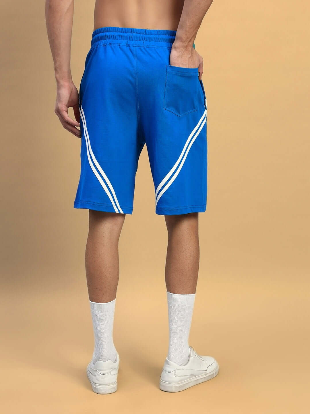 Model wearing STAR JUMPER Regular Fit Royal Blue Shorts, showcasing back design with white stripes, customizable size available.