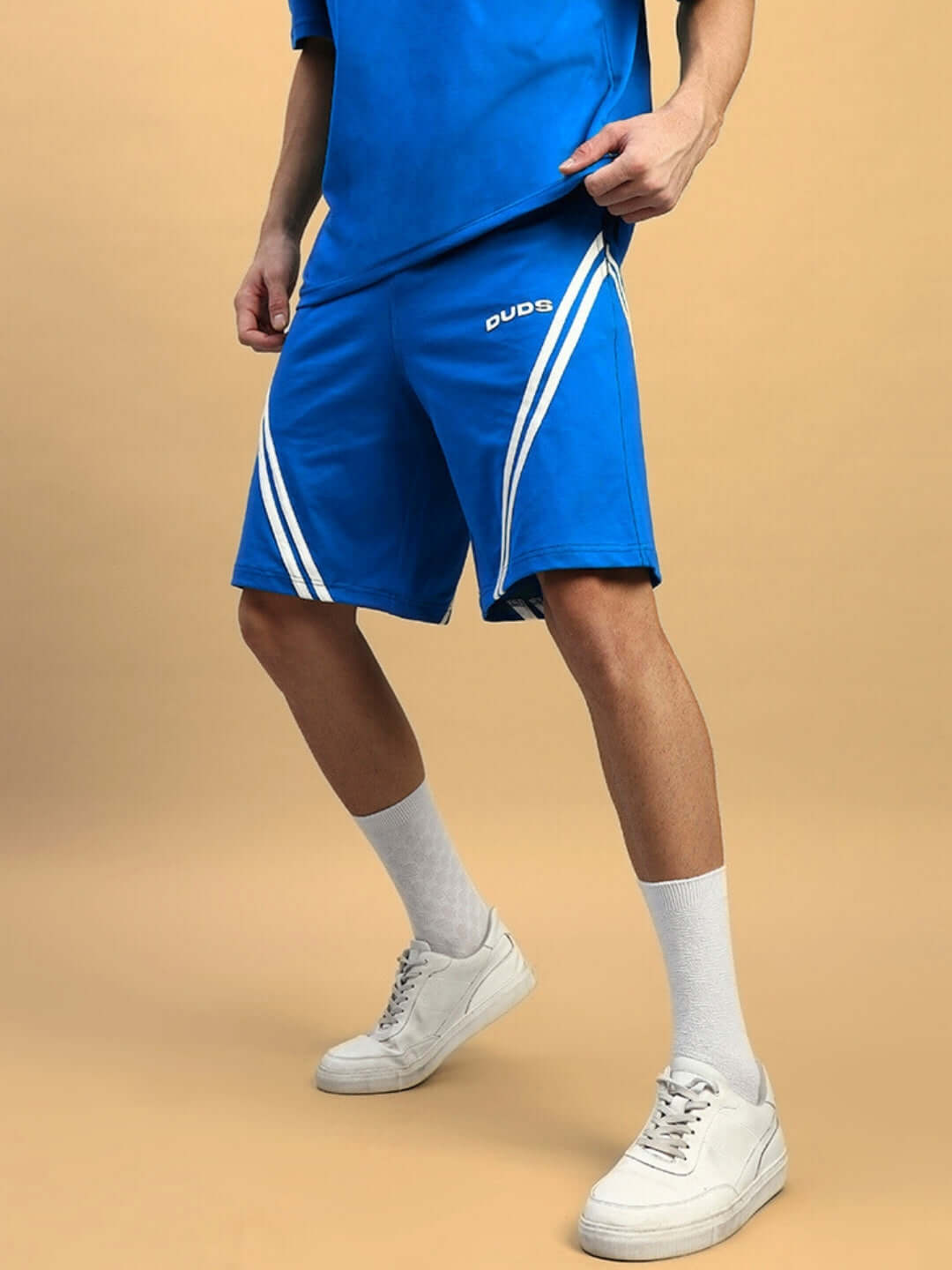 Man wearing STAR JUMPER Regular Fit Shorts in Royal Blue with white stripes, showcasing casual style.