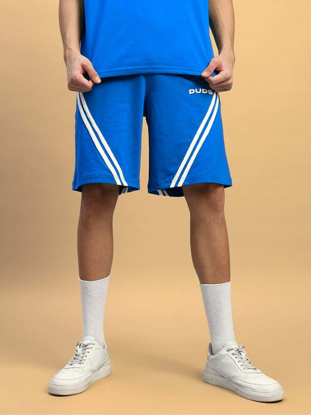 Man wearing STAR JUMPER Regular Fit Shorts in royal blue, showcasing sporty design with white stripes, by DUDS. Ideal for casual wear.