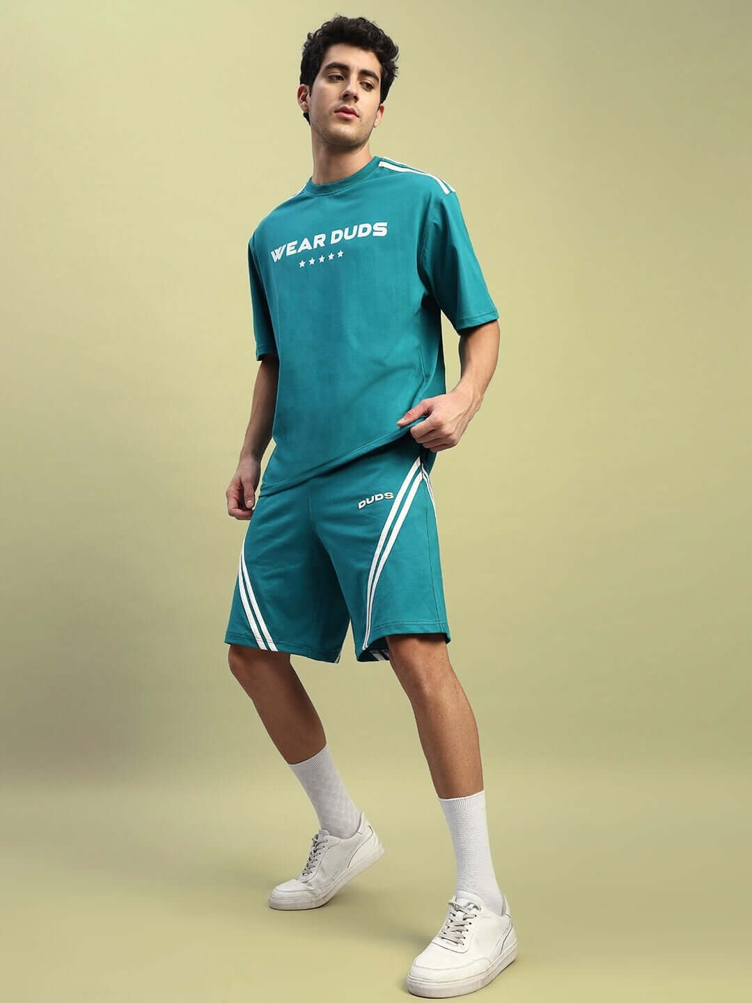 Model wearing STAR JUMPER Summer Co-ord Set in teal featuring premium cotton terry fabric, styled with white sneakers for a casual look.