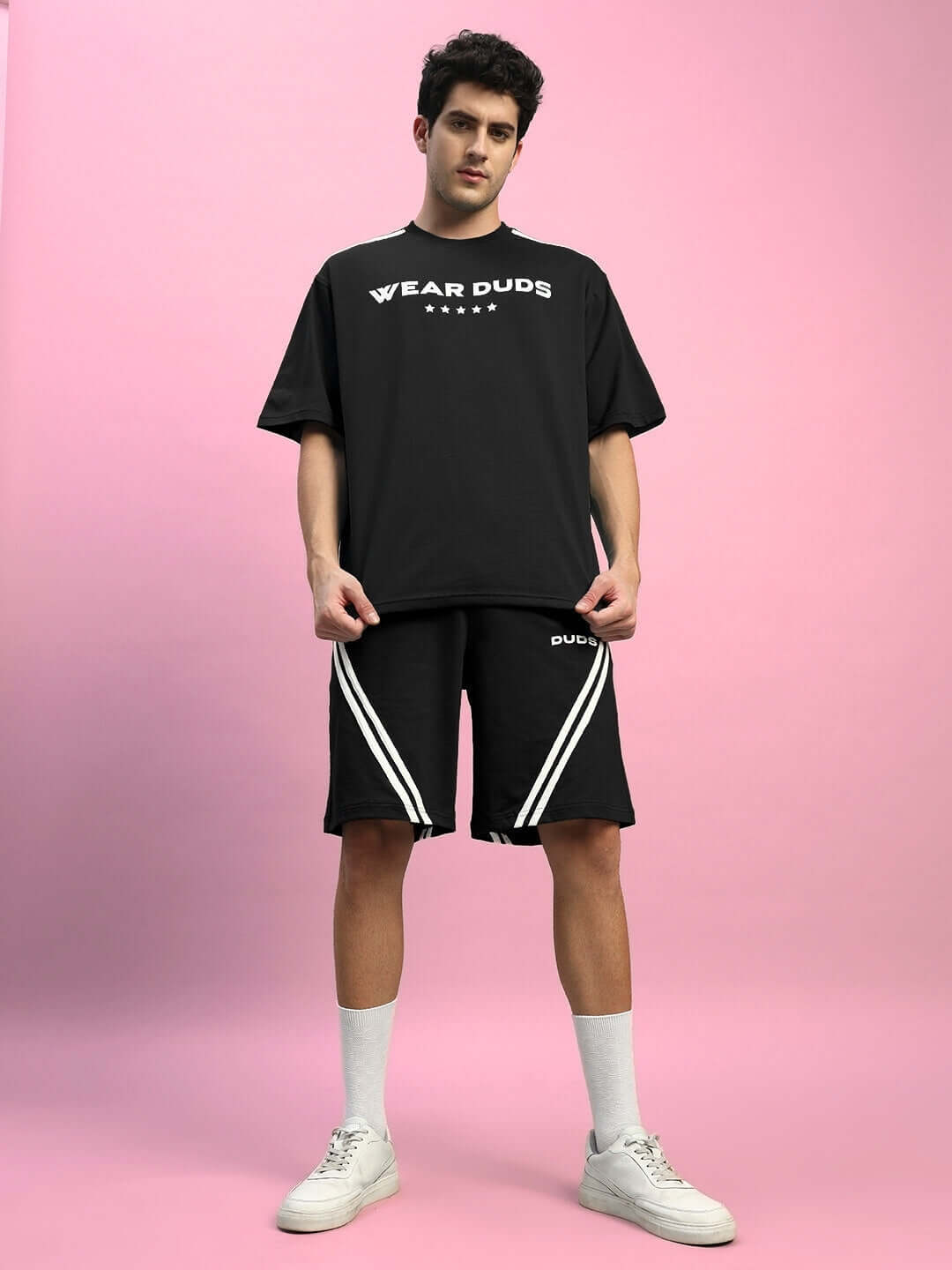 Model wearing STAR JUMPER Summer Co-ord Set in black, featuring premium cotton French Terry Lycra shorts with white sporty stripes.