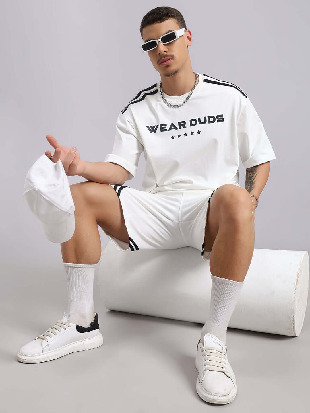 Man wearing Star Jumper Summer Co-ord Set in off white, featuring a premium heavy gauge cotton blend, posing stylishly with sunglasses and cap.
