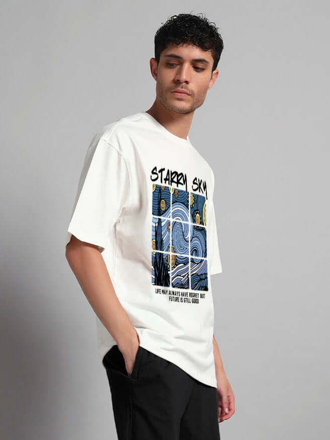 Man wearing off-white oversized t-shirt with starry sky graphic, showcasing relaxed streetwear style and celestial design.
