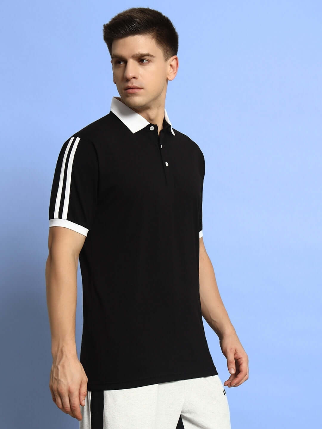 Model wearing STAUNCH Polo Regular Fit T-Shirt in black, half sleeves, premium cotton, comfortable for all-day wear, bio-washed, made in India.