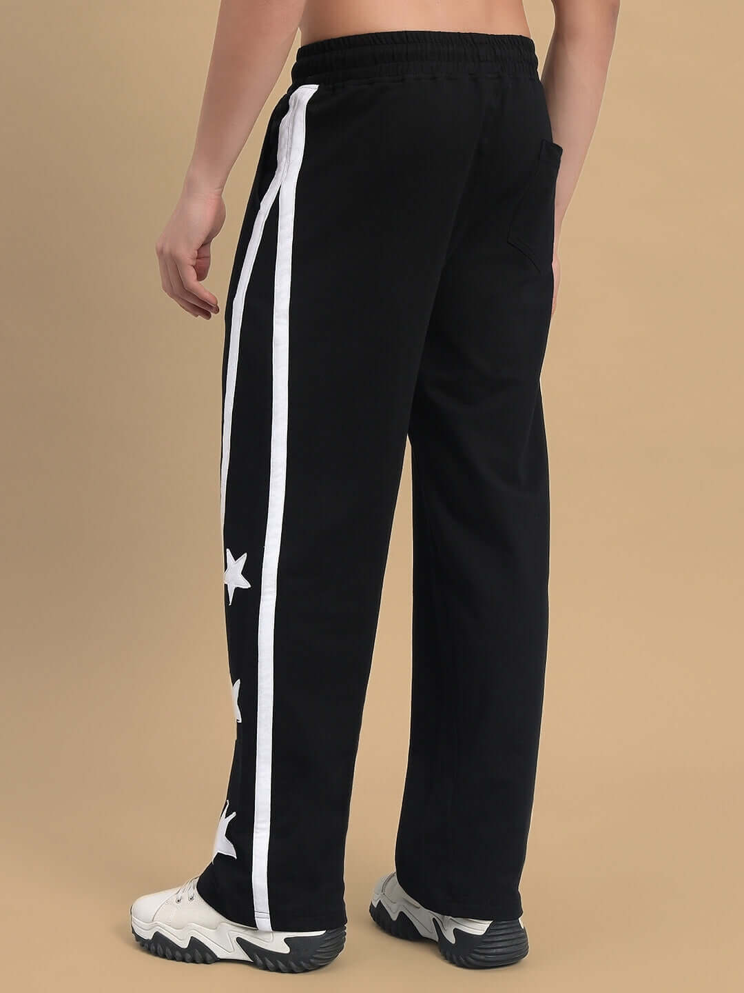 Back view of black Stellar Relaxed Joggers with white stripes and star design, showcasing casual style and comfort.