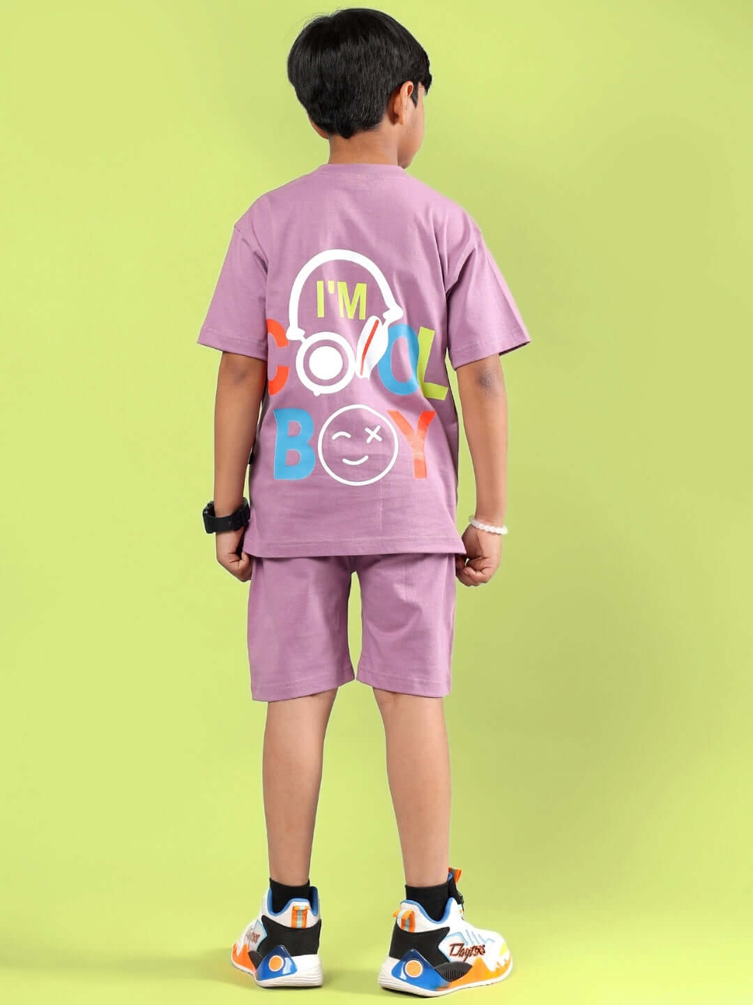A child wearing a purple co-ord set with colorful text, suitable for boys and girls. Stylish and customizable fashion from DUDS.