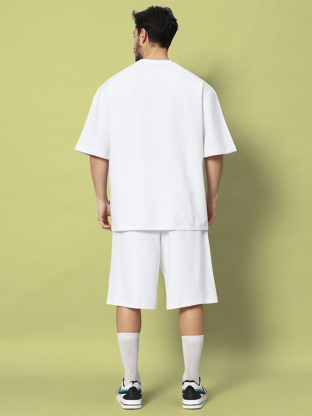 Model showcasing the STRATEGY RUSE CO-ORD SET WHITE from the back, featuring a relaxed fit and comfortable style.