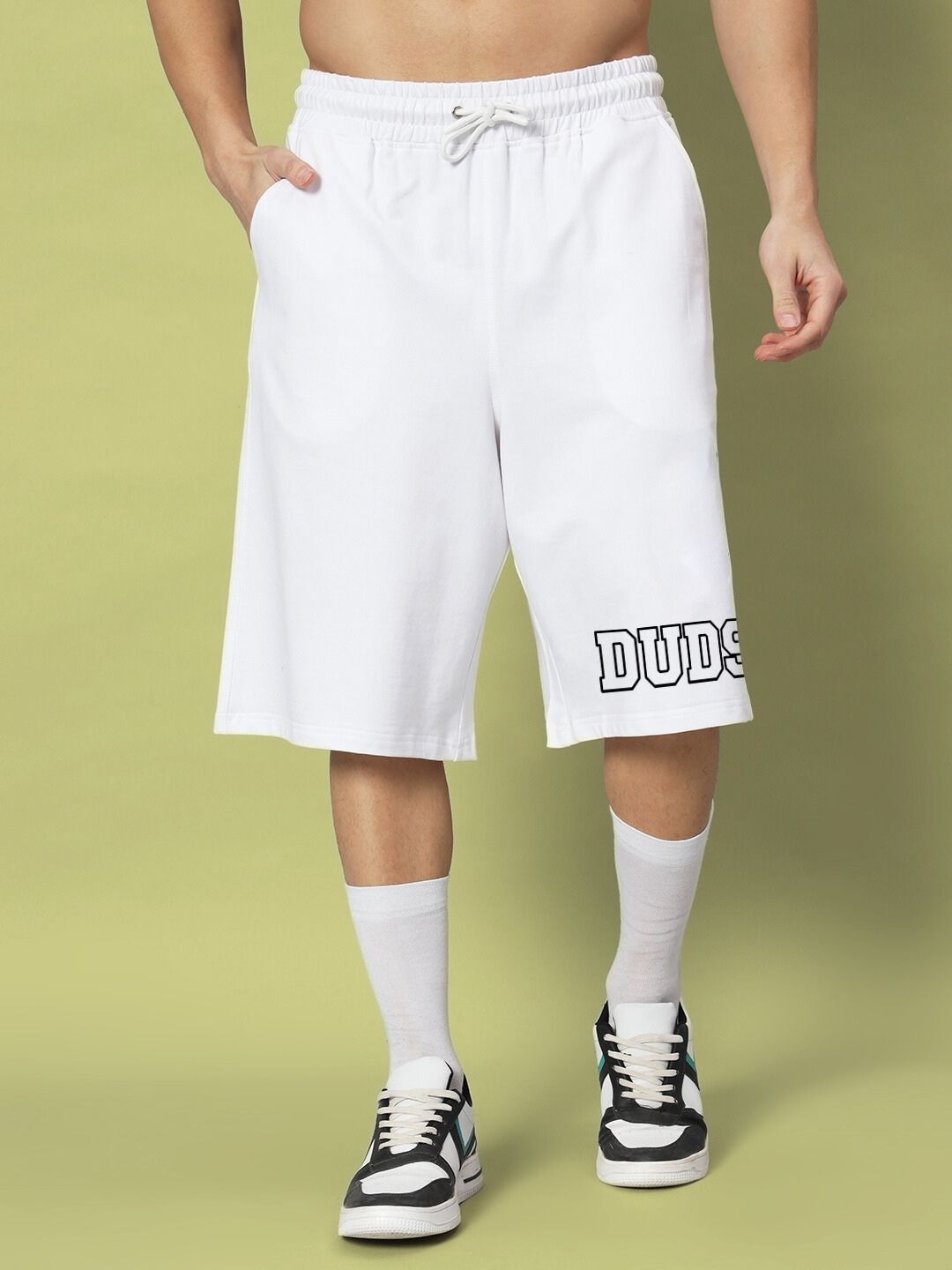 Model wearing white shorts from STRATEGY RUSE CO-ORD SET WHITE with sneakers, showcasing modern streetwear style