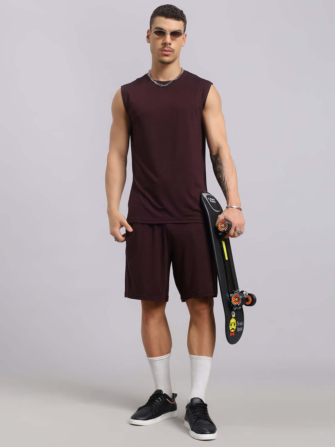 Man wearing Strength Freak Co-Ord Set in wine color, holding a skateboard, showcasing premium modal fabric. Perfect for stylish activewear.